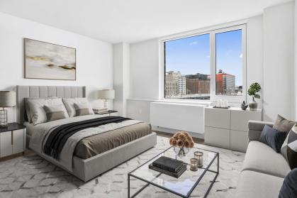 Bedroom at Bronx Point, brown bedding, glass coffee table, views of the Bronx and highway